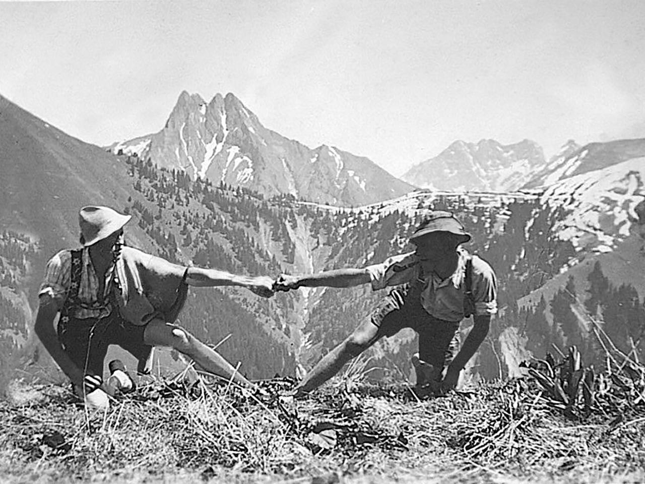 Männer in Tracht üben Fingerhakeln aus