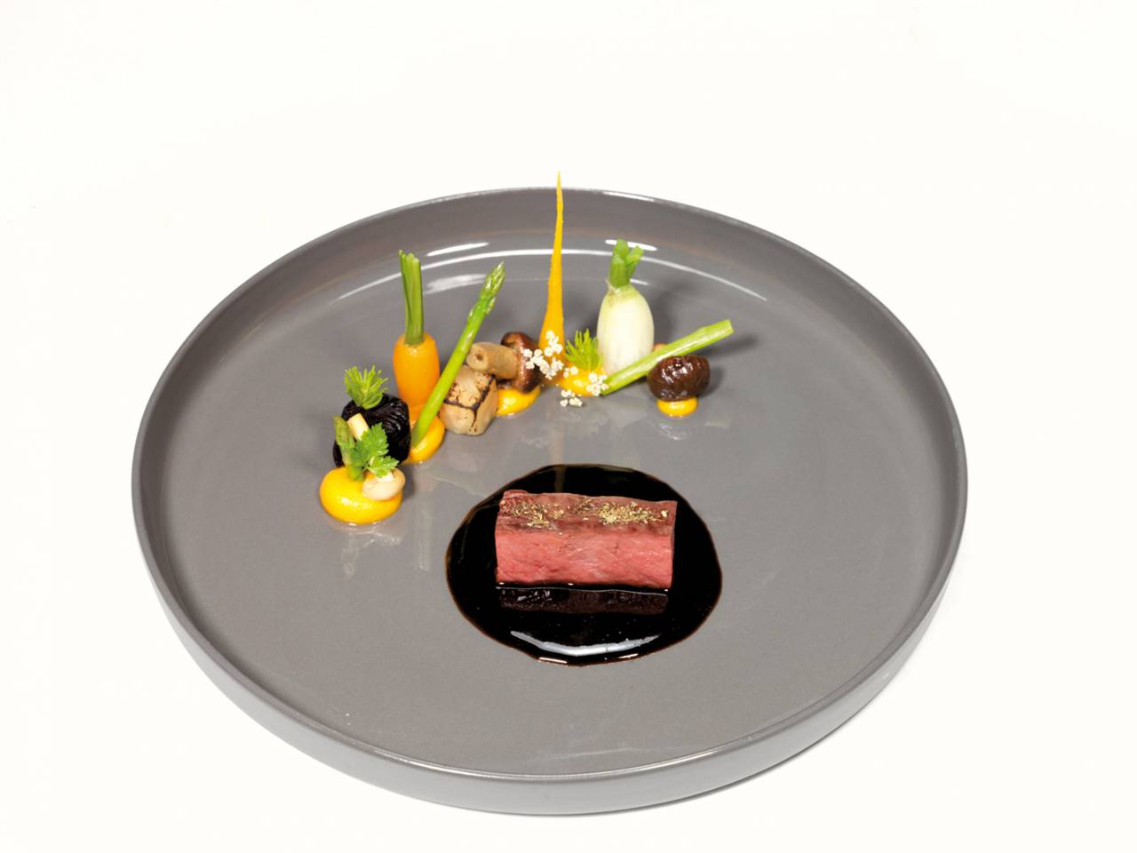 Gemüse dekoriert auf grauen Teller mit Rinderfilet